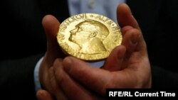 Një person mban në duar një medalje të Çmimit Nobel. Fotografi nga arkivi. 