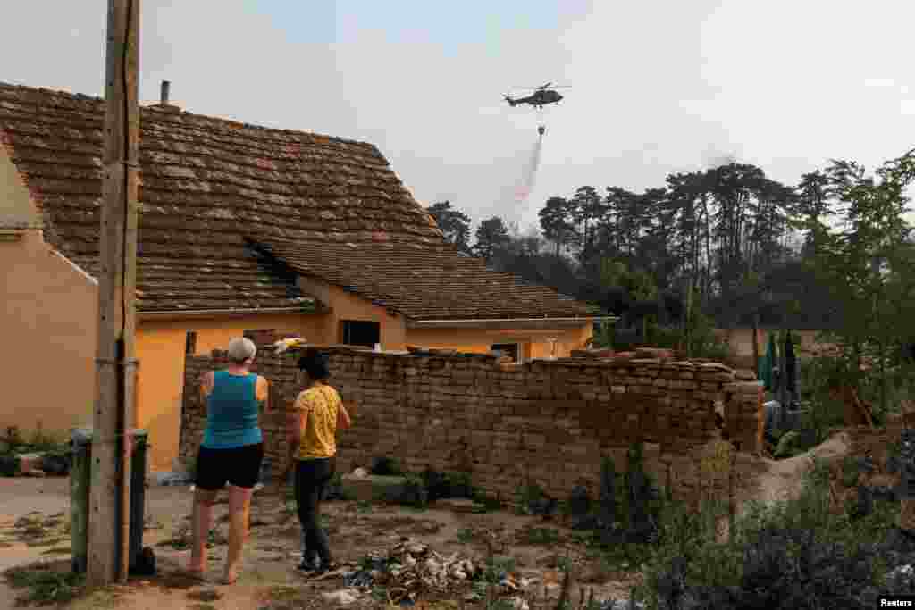 Danima se mogu vidjeti helikopteri za gašenje požara kako uzimaju vodu iz Dunava i pokušavaju da ugase požar. Selo Grebenac pored Deliblatske peščare, 20. avgust 2026. 