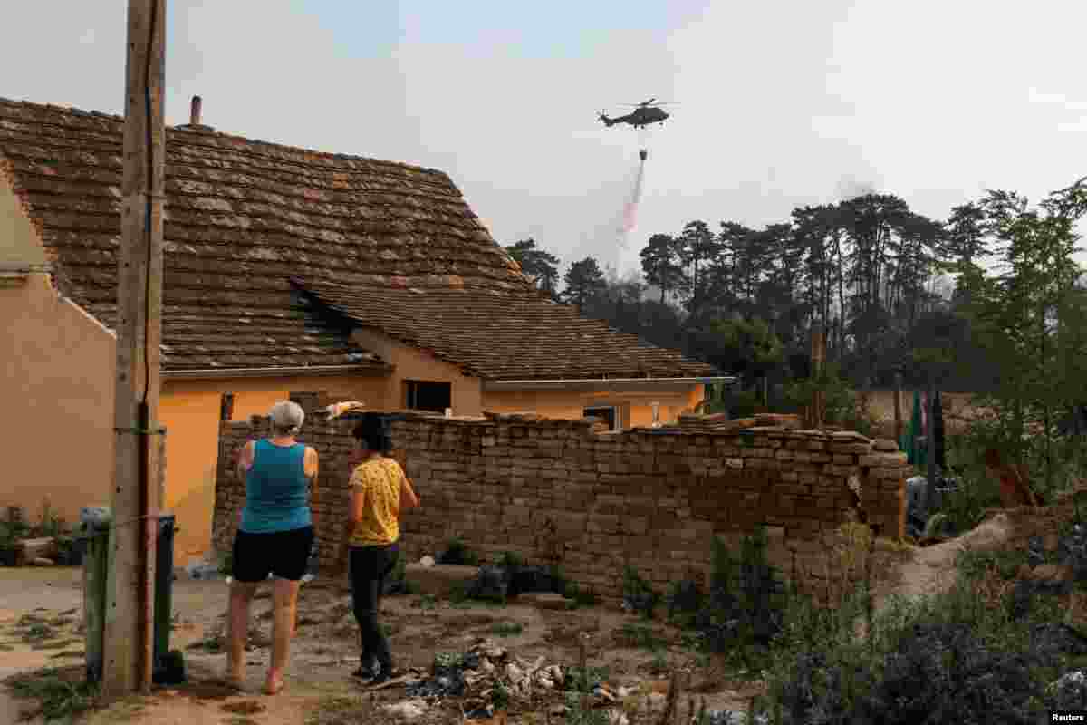 Danima se mogu vidjeti helikopteri za gašenje požara kako uzimaju vodu iz Dunava i pokušavaju da ugase požar. Selo Grebenac pored Deliblatske peščare, 20. avgust 2026. 