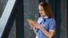 Shutterstock - Young beautiful woman standing with iPad and reading.