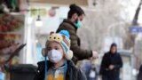 IRAN -- An Iranian child wearing face mask walks on a street of Tehran, February 26, 2020