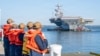 US Navy sailors stand by to moor the aircraft carrier USS Gerald R. Ford as it returns to Norfolk, Virginia, on May 16.