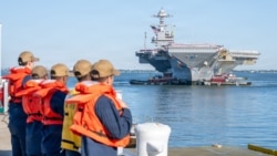 US Navy sailors stand by to moor the aircraft carrier USS Gerald R. Ford as it returns to Norfolk, Virginia, on May 16.