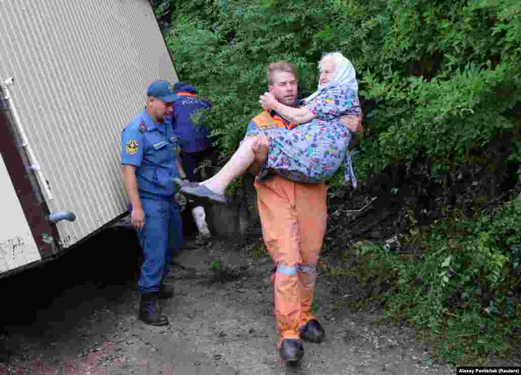 Un bărbat care participă la eforturile de salvare este văzut ducând o femeie în brațe în&nbsp;Kuibysheve.&nbsp;