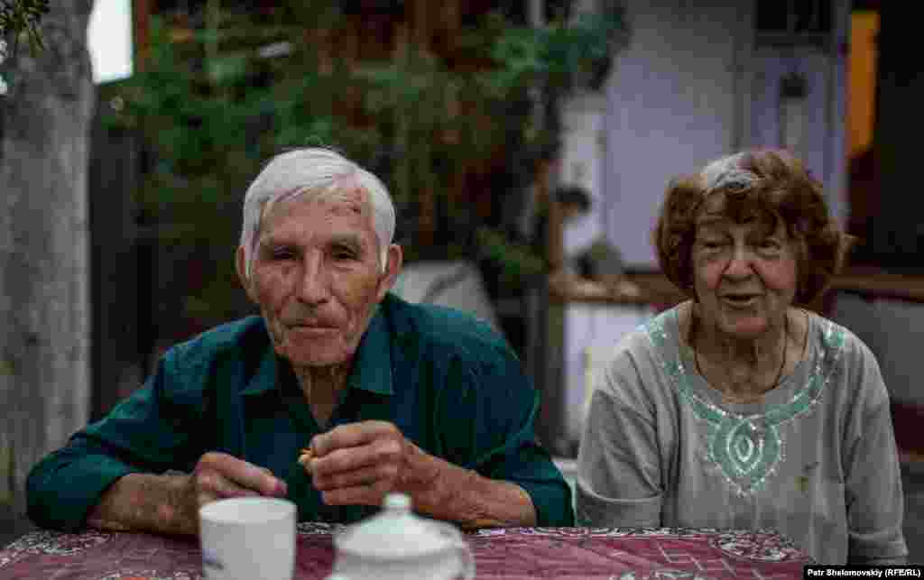 Vladimir and Herolda have tea in front of their house.