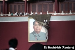 Mai mulți protestatari încearcă să acopere portretul lui Mao Zedong din piața Tiananmen, 23 mai 1989.