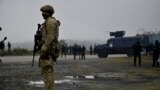 A US NATO soldier patrols next to Kosovo police special unit near the border between Kosovo and Serbia in Jarinje on October 2, 2021 as Serbs remove trucks and cars that used to block the border with Kosovo.