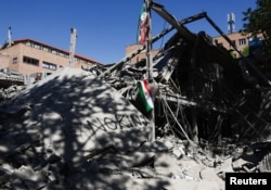 An Iranian flag hangs amid the rubble of a building at Tehran's Sharif University of Technology, which was damaged in a strike on April 7.