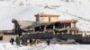 Afghan intelligence officers leave the collapsed building of Afghanistan's intelligence office following an attack in Wardak on January 21.