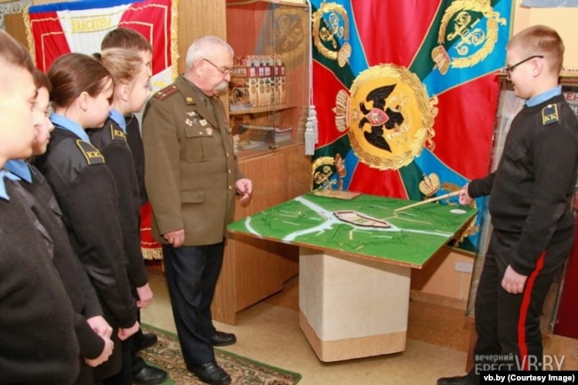 Віктар Пенза вядзе заняткі зь берасьцейскімі кадэтамі. На сьцяне вісіць адноўленая харугва часоў Расейскай імпэрыі.