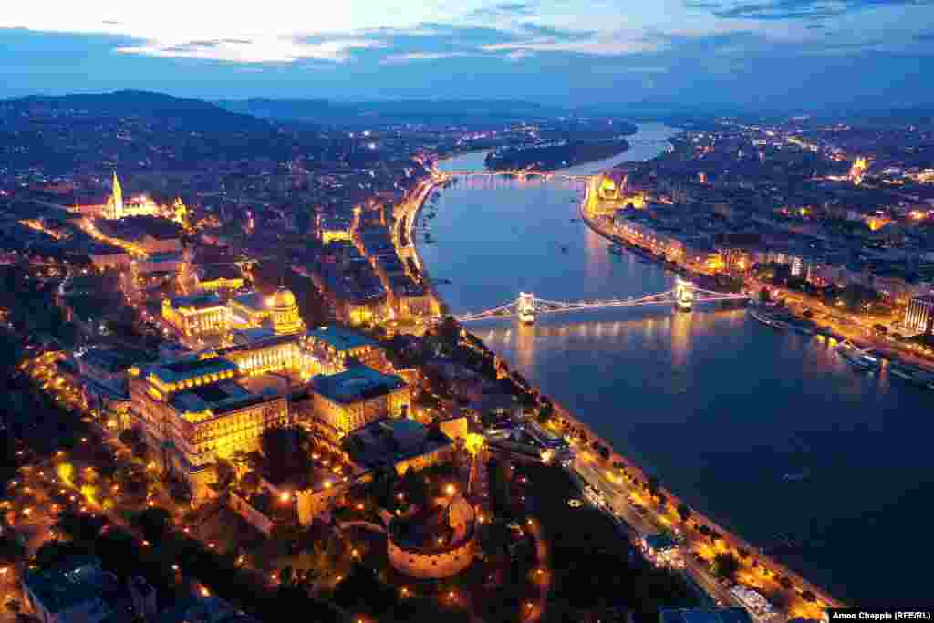 Buda Castle (left) glitters over the Danube at dusk.