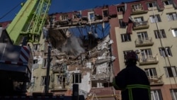 Ukrainian rescuers work at the site of a damaged residential building following a massive strike in Odesa on April 6.