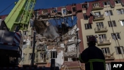 Ukrainian rescuers work at the site of a damaged residential building following a massive strike in Odesa on April 6.