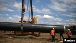 Workers move a section of pipe at a construction site on the extension of Russia's TurkStream gas pipeline in Letnitsa, Bulgaria, in June 2020. 