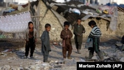 Internally displaced boys play outside their temporary home in Kabul. (file photo)