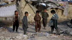 Дети временно перемещенных лиц на фоне мест их проживания в Кабуле. Январь 2021 года.