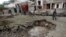 Afghan policemen walk past a crater at the site of a suicide attack at the Indian Consulate in Jalalabad on August 3. 