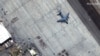 Crowds of people wait on the tarmac at Kabul&#39;s Hamid Karzai International Airport with a C-17 transport aircraft ready for takeoff on August 23.&nbsp;