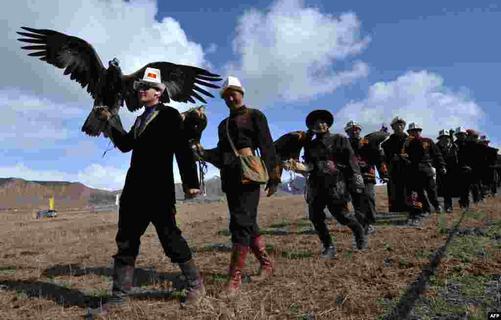 Kyrgyz berkutchi, or eagle hunters, carry their golden eagles during a hunting festival called Salburun in the village of Alysh, near Naryn, 350 kilometers outside Bishkek. (AFP/Vyacheslav Oseledko)