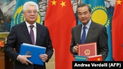 Kazakh Foreign Minister Beibut Atamkulov (left) and Chinese Foreign Minister Wang Yi attend a signing ceremony at the Diaoyutai State Guesthouse in Beijing on March 28.