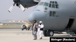 Talibani na aerodromu u Kabulu pored vojnog aviona dan nakon što su američke trupe napustile Avganistan, 31. avgust 2021. 