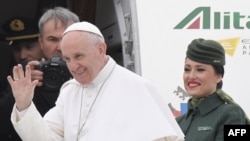 Pope Francis waves to reporters before embarking on an historic visit to Egypt. 