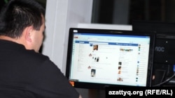 Мужчина у компьютера просматривает страницу Facebook'а. 