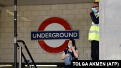 Egy maszkot viselő nő távozik a metróból London központjában 2021. június 6-án