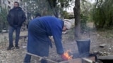 Ukraine - civilians with no access to gas or electricity build a fire in Kostyantynivka - screen grab