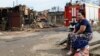 A local resident sits at the site of the fire in central Rostov that damaged or destroyed 123 residential buildings and killed one man. 