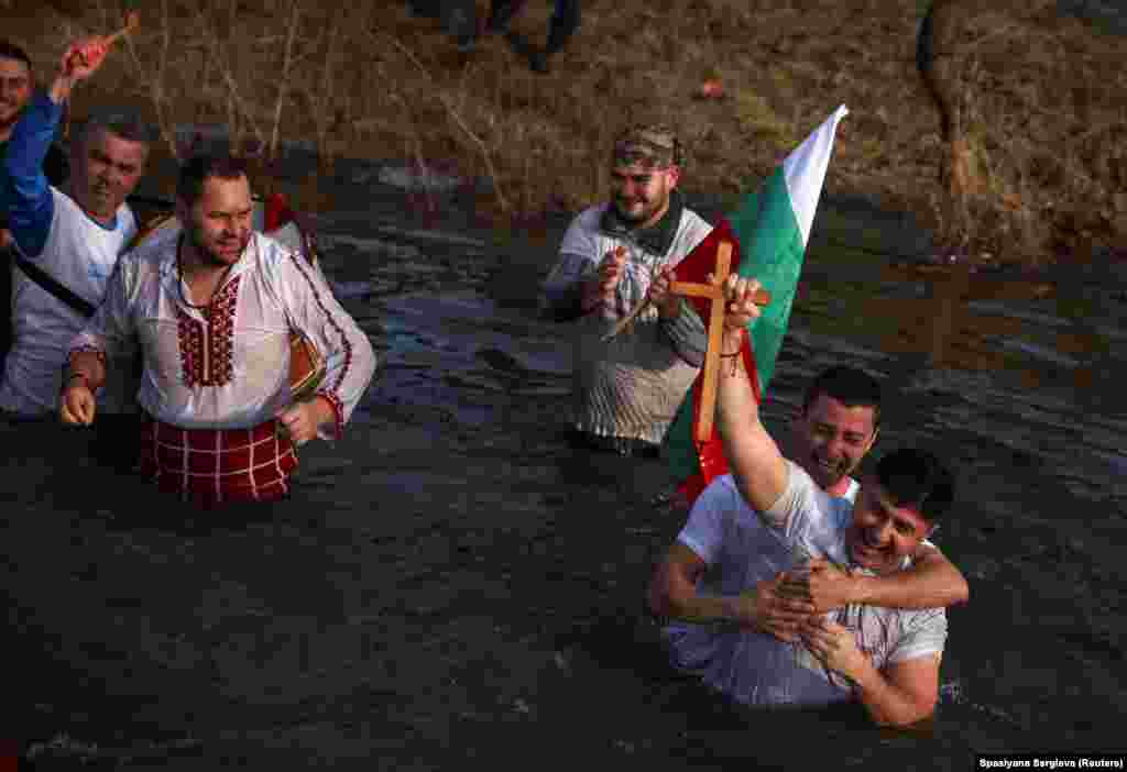 Bulgarian men sing and dance in river water during their country&#39;s celebrations of the feast of the Epiphany on January 6.&nbsp;