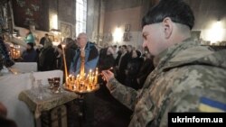 Військовослужбовець ставить свічку під час Різдвяного богослужіння в соборі святого Івана Богослова, Харків, 7 січня 2016 року 