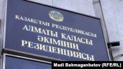 Табличка у входа в здание акимата Алматы.