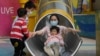 Një grua luan me disa fëmijë në Kinë. 