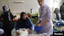 A midwife helps a mother with her newborn baby at the Razai Foundation Maternity Hospital in Herat. In Afghanistan, not having a son can doom a mother's marriage.