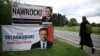 O femeie, trecând pe lângă panouri electorale ale candidaților la alegerile prezidențiale din Polonia, în orașul Pabianice din centrul țării, înainte de turul doi de scrutin, de pe 1 iunie 2025