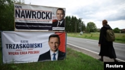 O femeie, trecând pe lângă panouri electorale ale candidaților la alegerile prezidențiale din Polonia, în orașul Pabianice din centrul țării, înainte de turul doi de scrutin, de pe 1 iunie 2025