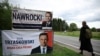 O femeie, trecând pe lângă panouri electorale ale candidaților la alegerile prezidențiale din Polonia, în orașul Pabianice din centrul țării, înainte de turul doi de scrutin, de pe 1 iunie 2025