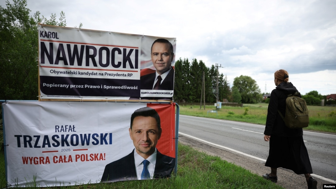 O femeie, trecând pe lângă panouri electorale ale candidaților la alegerile prezidențiale din Polonia, în orașul Pabianice din centrul țării, înainte de turul doi de scrutin, de pe 1 iunie 2025