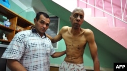 Cuban opposition activist Guillermo Farinas (right) stands with the help of a doctor at his home in Santa Clara, Cuba, in March.