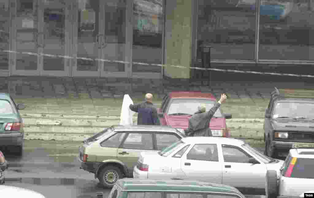 Representatives of Doctors Without Borders (Medecins Sans Frontieres) wave a white flag in an effort to gain access to the hostages on the morning of October 24.