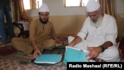 Kleriku Mian Mohammad Javed (djathtas) dhe djali i tij, Mian Noor Muhammad, me ditarin e të konvertuarve në Islam.