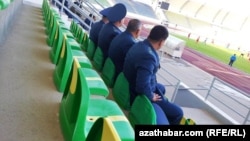 Polisiýa işgärleri futbola tomaşa edýärler.