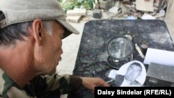 Rashid painstakingly chisels a portrait for a fresh gravestone. He says it can take him an entire week to complete a single tombstone, complete with portrait. They can sell for as much as 5,000 som, or $110. 