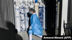 Një punonjëse mjekësore kalon pranë bombulave të oksigjenit në Klinikën për Sëmundjet Infektive në Prishtinë, 27 nëntor 2020. 