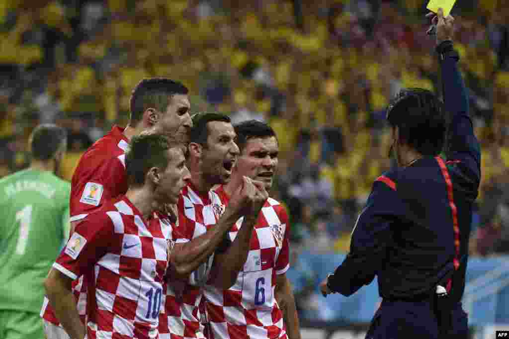 Brazil -- Croatia's midfielder Luka Modric (front), Croatia's defender and captain Darijo Srna (C) and Croatia's defender Dejan Lovren (back) react as Japanese referee Yuichi Nishimura gives a penalty to Brazil during a Group A football match between Braz