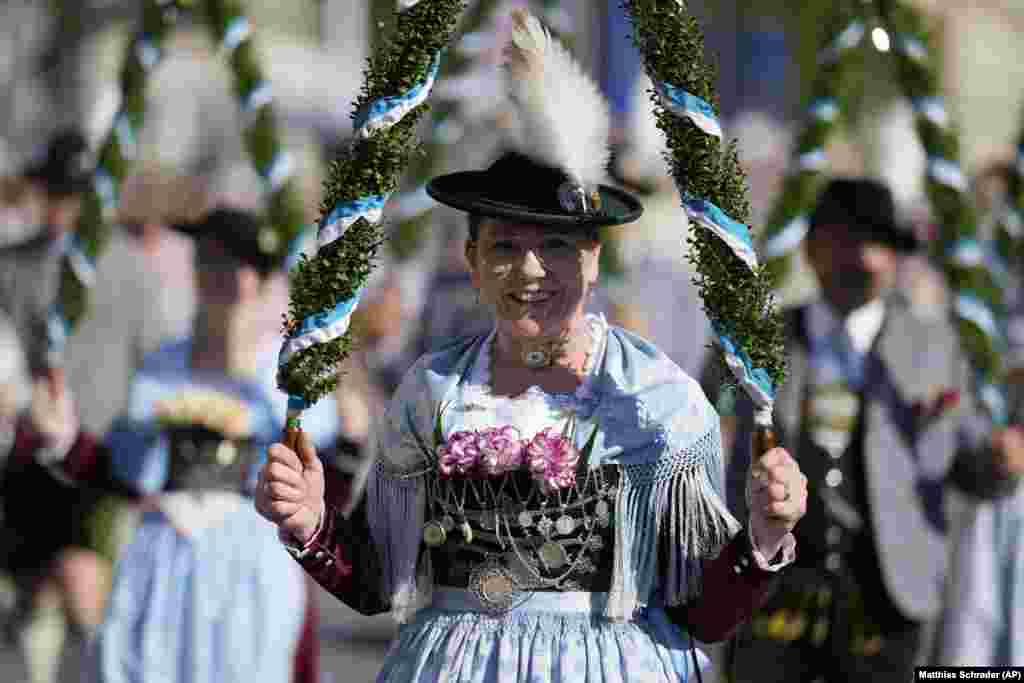 Një grua e veshur me një kostum tradicional buzëqesh derisa merr pjesë në paradën e qitësve, një ndër aktivitetet e shumta në kuadër të festivalit të 189-të të birrës Oktoberfest në Munih, Gjermani, i cili do të mbahet nga 21 shtatori deri më 6 tetor.