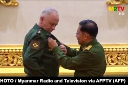Бирманын хунта башчысы, улук генерал Мин Аунг Хлайн Орусиянын коргоо министринин орун басары Александр Фоминге медал тагууда. Найпидо шаары, Бирма. 2021-жылдын 26-марты.