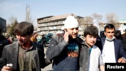 People assist an injured man after a blast in Kabul on January 27.