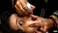 Health worker administers polio vaccine to a child in Pakistan.